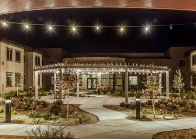 senior living community exterior landscaping with bistro lights
