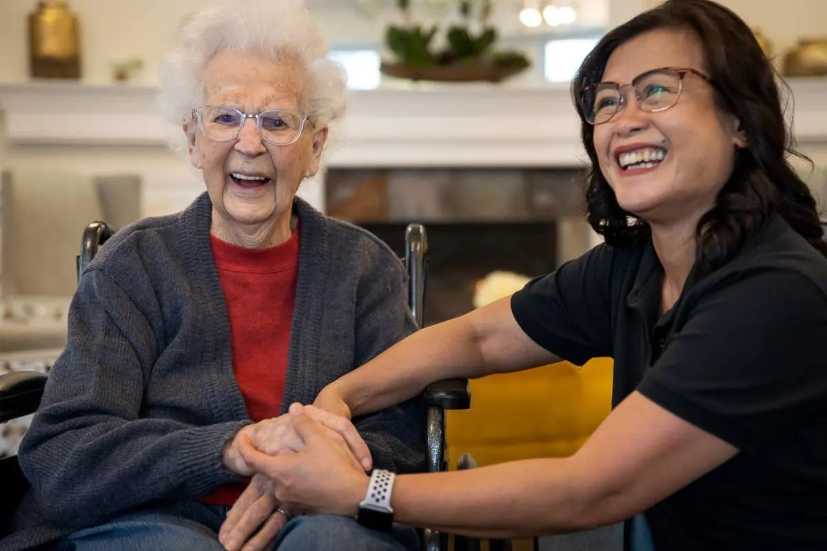 elderly woman holding hands with caregiver